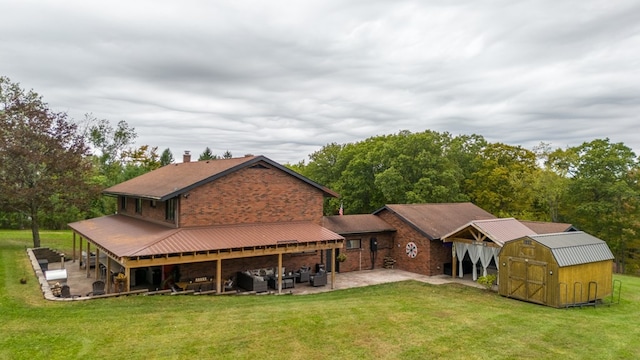 back of house with a lawn, outdoor lounge area, a patio, and a storage shed