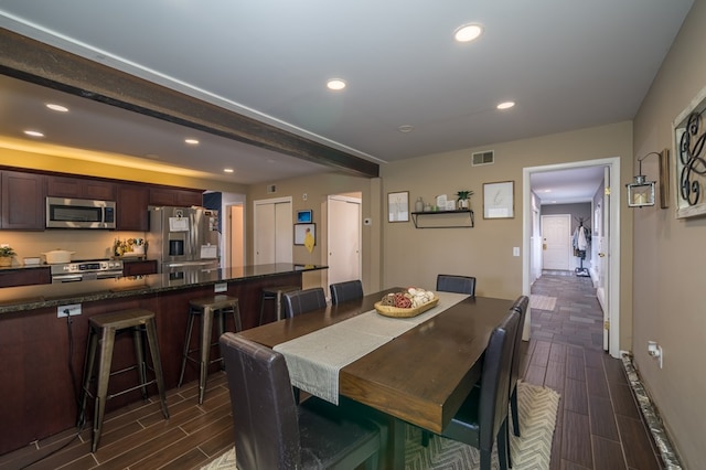 dining area featuring beamed ceiling