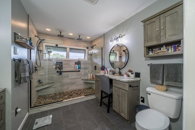 bathroom featuring vanity, a shower with shower door, and toilet