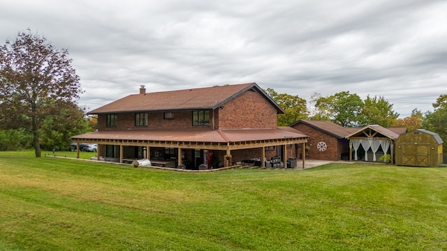 rear view of house with a yard, a patio, and a storage unit