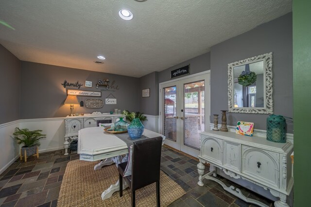 dining space featuring french doors and a textured ceiling