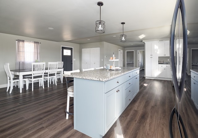 kitchen with white cabinetry, stainless steel fridge, a center island, and dark hardwood / wood-style floors