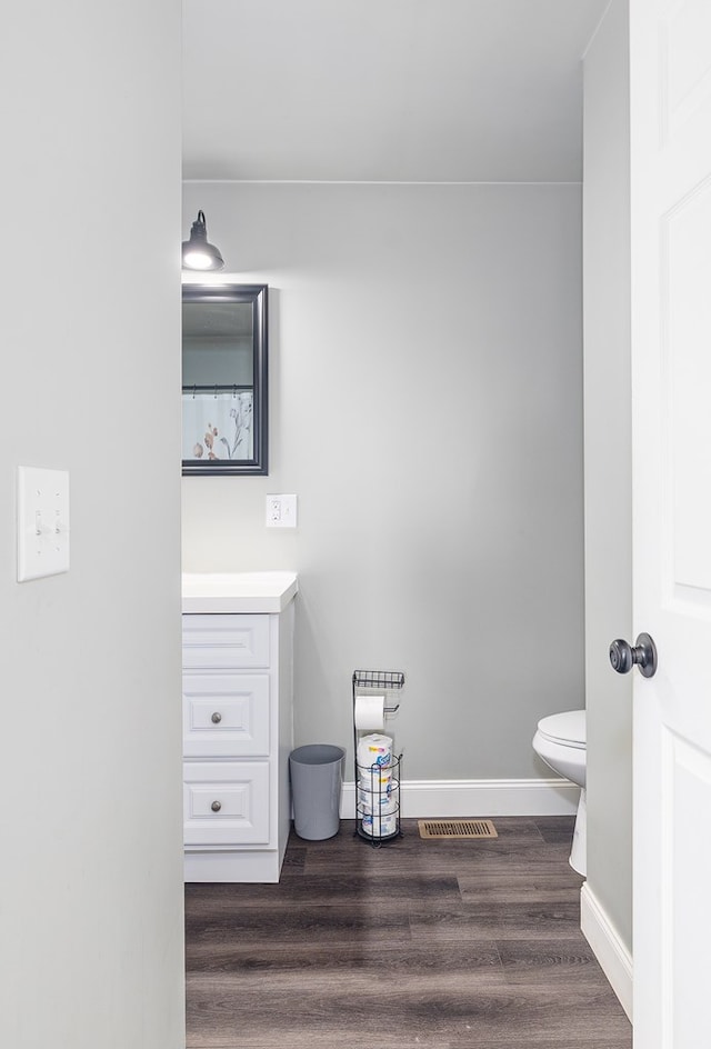 bathroom featuring vanity, toilet, and wood-type flooring