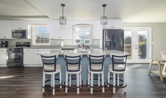 kitchen featuring a wealth of natural light, hanging light fixtures, and stainless steel appliances