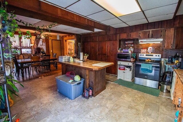 145 Tracy Brewer Rd, Meshoppen, PA 18630 - kitchen with appliances with stainless steel finishes, under cabinet range hood, wooden walls, a paneled ceiling, and light countertops