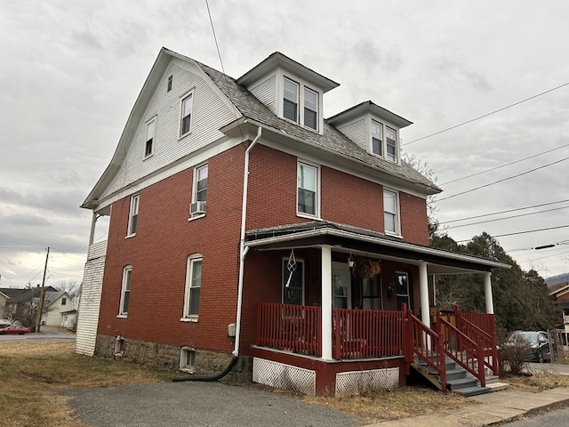 view of front of house with cooling unit and a porch