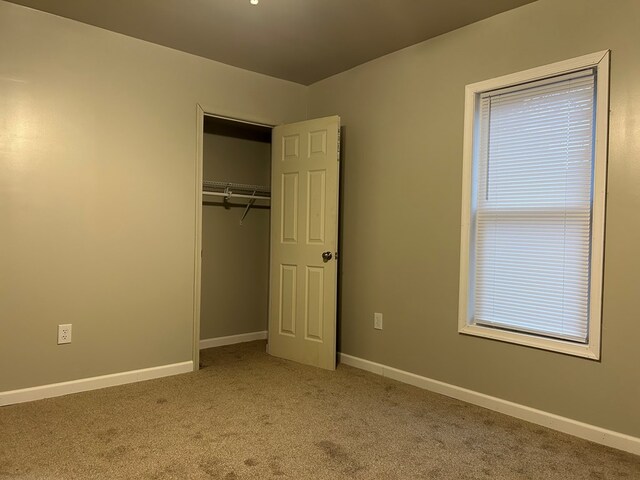 unfurnished bedroom with carpet floors and a closet