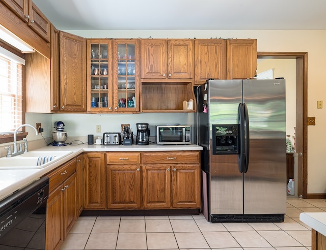 kitchen with light tile patterned flooring, stainless steel fridge, black dishwasher, and sink