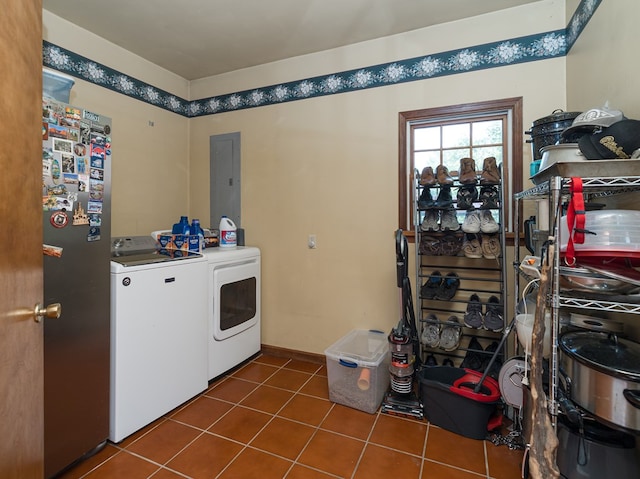 clothes washing area featuring electric panel, washer and clothes dryer, and dark tile patterned floors