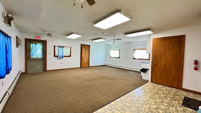 carpeted empty room featuring a baseboard heating unit, ceiling fan, and baseboards