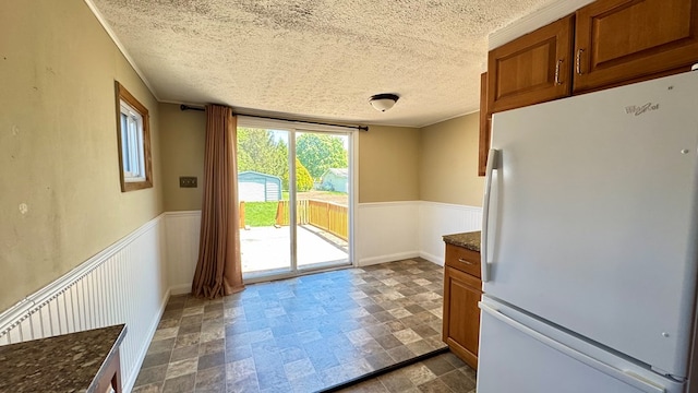 doorway featuring a textured ceiling and baseboards
