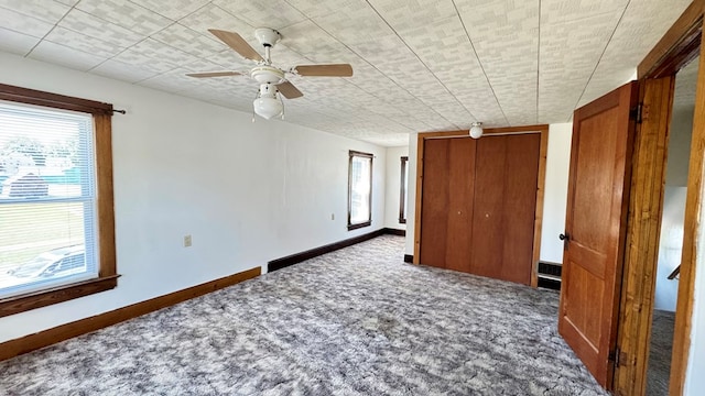 unfurnished bedroom with carpet, baseboards, and a ceiling fan
