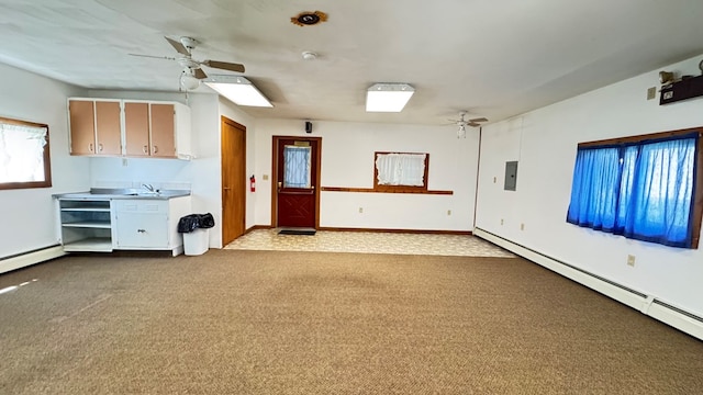 carpeted spare room with a ceiling fan, a baseboard radiator, electric panel, and baseboards