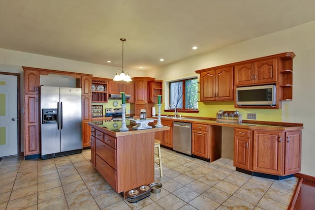 kitchen with a center island, hanging light fixtures, stainless steel appliances, a breakfast bar area, and light tile patterned flooring