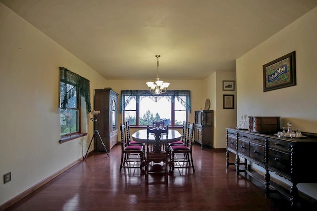 dining space featuring dark hardwood / wood-style floors and an inviting chandelier