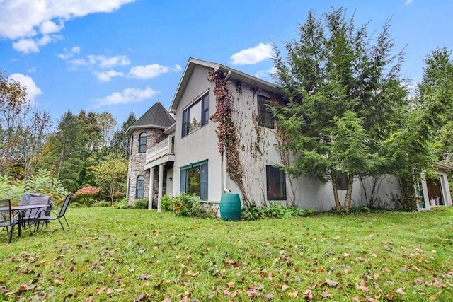 view of property exterior featuring a lawn and a balcony