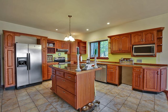 kitchen with stainless steel appliances, light tile patterned floors, decorative light fixtures, a chandelier, and a center island