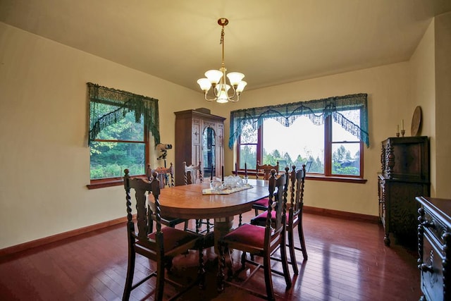 dining space featuring dark wood-type flooring and a notable chandelier