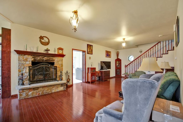 living room with hardwood / wood-style floors and a stone fireplace