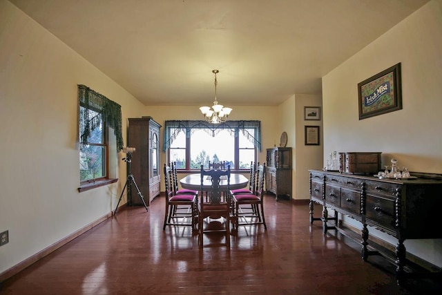 dining room with dark hardwood / wood-style flooring and a notable chandelier