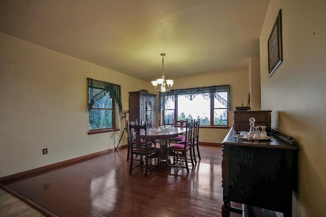 dining space featuring dark hardwood / wood-style flooring and an inviting chandelier