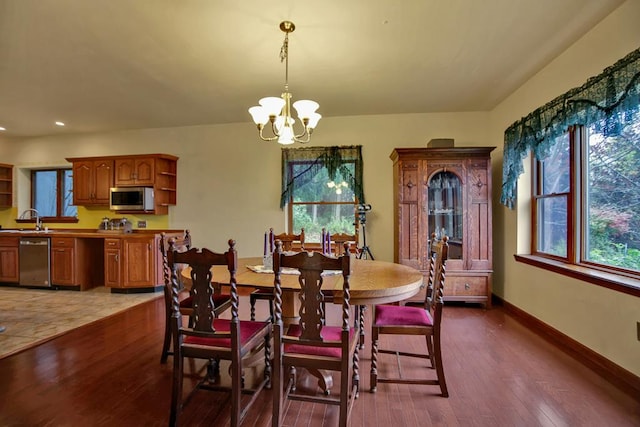 dining room featuring dark hardwood / wood-style flooring, sink, and an inviting chandelier