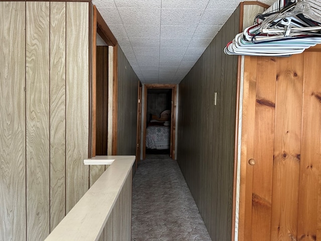 hallway featuring wood walls