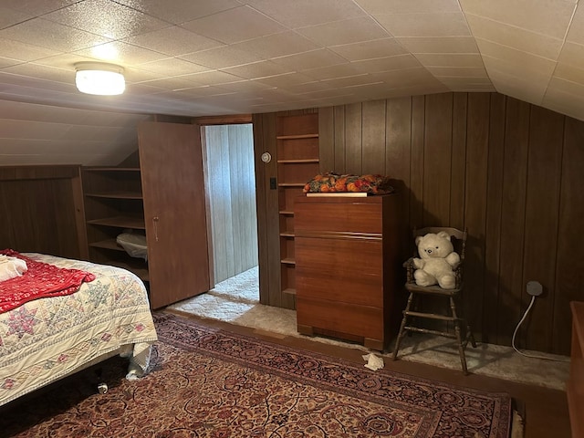 bedroom with wood walls and vaulted ceiling