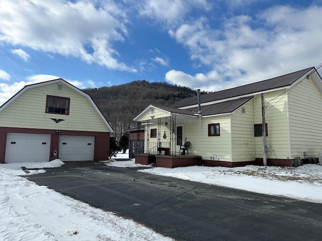 view of front of home with a mountain view, covered porch, and a garage