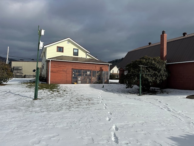 view of snow covered back of property