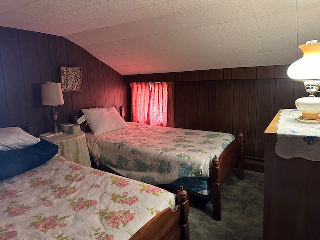 carpeted bedroom with wooden walls and vaulted ceiling