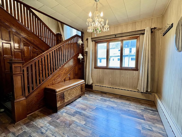 213 2nd St, Harrison Valley, PA 16927 - staircase with a chandelier, wood finished floors, wooden walls, and ornamental molding