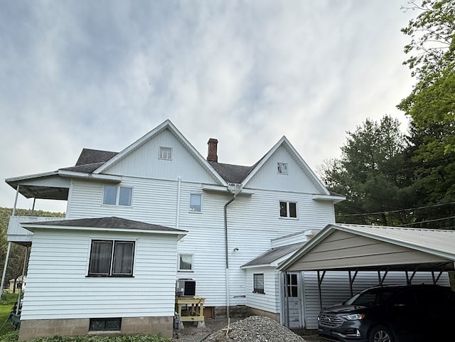213 2nd St, Harrison Valley, PA 16927 - rear view of house featuring a carport, a chimney, a shingled roof, and central AC unit