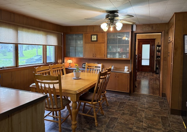 213 2nd St, Harrison Valley, PA 16927 - dining room with wood walls, a ceiling fan, and dark stone finish flooring