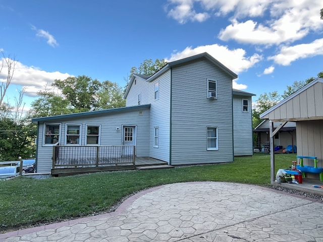 back of house featuring a lawn and a wooden deck