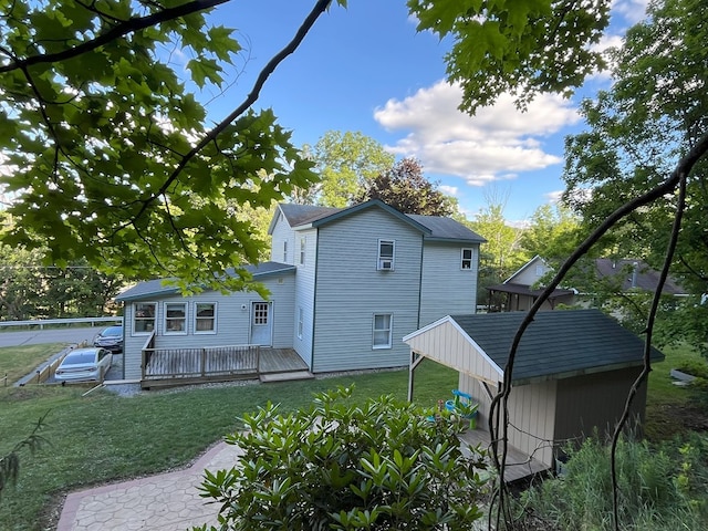 back of property featuring a lawn and a wooden deck