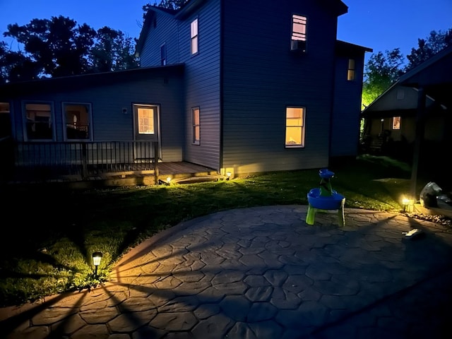 rear view of house with a deck, a patio, and a yard