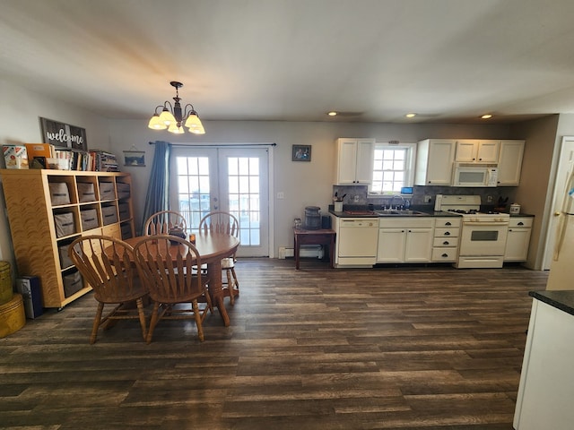 dining area featuring a chandelier, a baseboard radiator, recessed lighting, dark wood-type flooring, and french doors