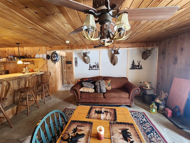 living room featuring wooden ceiling, wood walls, and a bar