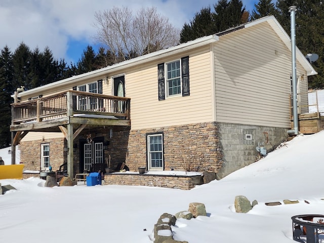 view of front of home featuring stone siding and a deck