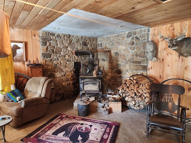 living area with a wood stove, wood walls, and wood ceiling