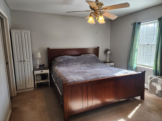 bedroom with ceiling fan, dark colored carpet, and multiple windows