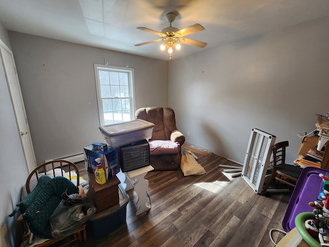 sitting room featuring ceiling fan, a baseboard radiator, and dark wood finished floors