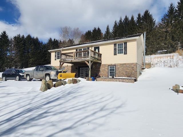 view of front of house with stone siding and a wooden deck