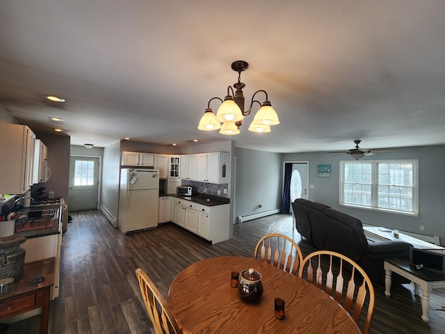 dining area with dark wood-style floors, a baseboard radiator, baseboards, and ceiling fan