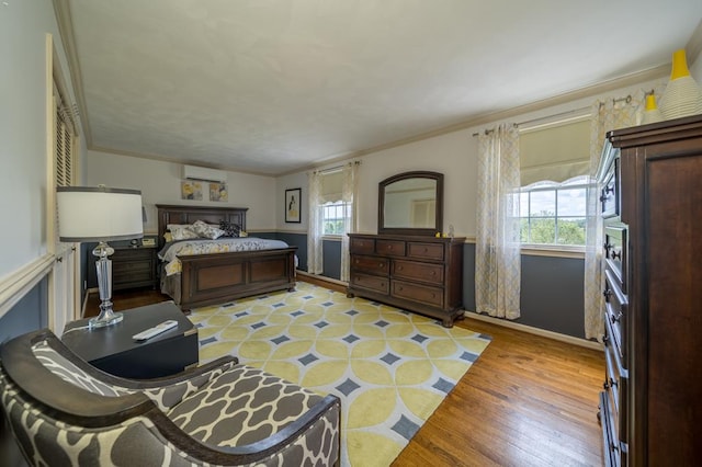 bedroom featuring multiple windows, crown molding, a wall unit AC, and light hardwood / wood-style floors