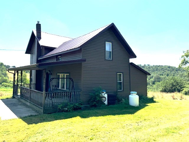 view of home's exterior with a lawn and covered porch