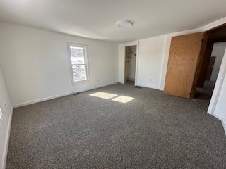 unfurnished bedroom featuring dark carpet