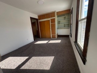 unfurnished bedroom with dark colored carpet