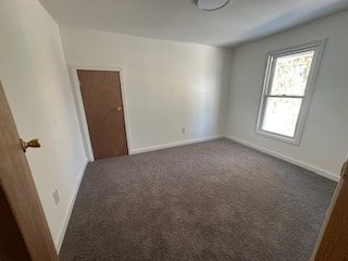 spare room with dark carpet